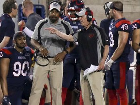 Montreal Alouettes defensive coordinator Bob Slowik, right, gestures toward the field during sideline while conferring with head coach Khari Jones during game against the Hamilton Tiger-Cats in Montreal on July 4, 2019.