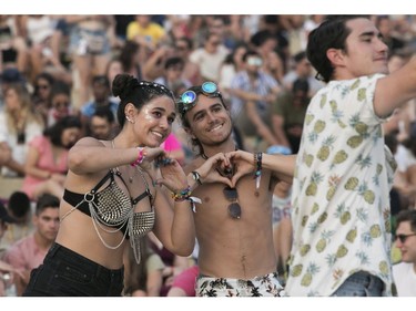 Lydia Shields and Michael Delima make a sign of the heart on Day 2 of the Osheaga Music and Arts Festival at Parc Jean-Drapeau in Montreal Saturday, August 3, 2019. Delima (from Toronto) and Shields (of New Jersey) had just met when the latter was drawn to him as he was sharing a message of love, saying "All is an illusion, there is only love."