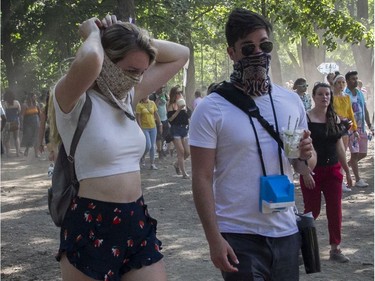 People cover their faces against the dust on Day 3 of the Osheaga Music and Arts Festival at Parc Jean-Drapeau in Montreal Sunday, August 4, 2019.