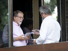 Hampstead mayor William Steinberg, left, is served papers by a baliff in Montreal on Thursday, Aug. 8, 2019.