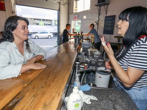 Alexandraplatz co-owner Bernadette Houde, left, talks with bartender Annie Quenneville at the bar on Thursday, Aug. 15, 2019.