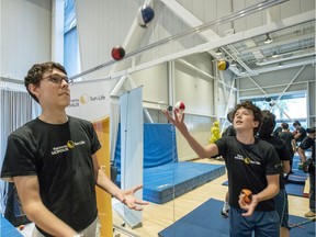 Jedrick McDonald, left, and Justin Morneau from the Boys and Girls Club of Longueuil try juggling during interactive day camp at the Cirque du Soleil headquarters in Montreal.