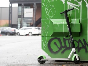 A Lime scooter is parked next to a Dumpster in Montreal on Aug. 21, 2019.