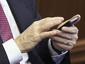 MONTREAL, QUE.: December 16, 2014 -- Richard Bergeron, former Projet Montreal leader and current member of the executive committee holds a pen in his mouth while consulting his smartphone during meeting of the Montreal city council at City Hall in Montreal Tuesday December 16, 2014. (John Mahoney / MONTREAL GAZETTE)