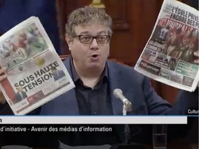 Journalism professor Patrick White holds copies of Quebec City newspapers Le Soleil and Le Journal de Québec as he appears before a National Assembly committee hearing into the future of media on Monday, Aug. 26, 2019.