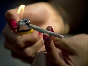 A young woman lights a marijuana joint during a march for the legalization of cannabis in Santiago, on May 5, 2012, as part of the 2012 Global Marijuana March which is being held in hundreds of cities worldwide. AFP PHOTO / Martin BERNETTIMARTIN BERNETTI/AFP/GettyImages