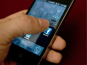 (FILES) In this May 10, 2012 file photo, an Apple iPhone displaying the Facebook app's splash screen is seen in Washington, DC. American parents may not have the resources of the National Security Agency, but it's not that hard for them to snoop on their smartphone-addicted kids.  AFP PHOTO / BRENDAN SMIALOWSKIBRENDAN SMIALOWSKI/AFP/Getty Images