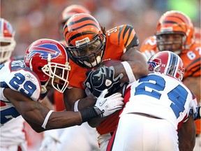 Cedric Benson of the Cincinnati Bengals is tackled by Drayton Florence  and Terrence McGee of the Buffalo Bills.