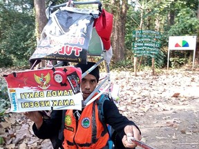 This handout courtesy of Medi Bastoni taken and released on August 5, 2019 shows Bastoni as he takes a selfie during a quick stop in Kendal, during his ongoing campaign to draw attention to the issue of deforestation in Indonesia. - Bastoni is walking 700-kilometres (435 miles) from his home on a volcano in East Java to Jakarta in the hope of drawing attention to the archipelago's quickly shrinking forests -- and he is doing it backwards.