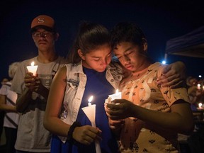 People pray during a candlelight vigil at the Immanuel Church for victims of a shooting that killed 22 people at a WalMart in El Paso. President Donald Trump has said little about gun control in the days since.
