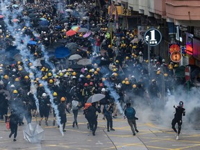 Tear gas is fired by police at protesters in Sham Shui Po in Hong Kong on August 11, 2019, in the latest opposition to a planned extradition law that was quickly evolved into a wider movement for democratic reforms. - Thousands of pro-democracy protesters hit the streets of Hong Kong for a tenth weekend in-a-row on August 11, again defying police who fired volleys of tear gas at several locations.
