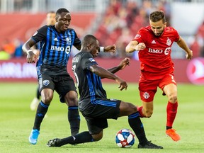 Montreal Impact defender Zachary Brault-Guillard (15) slide tackles Toronto FC forward Jordan Hamilton (7) during the first half at Rogers Centre on Saturday, Aug. 24, 2019.