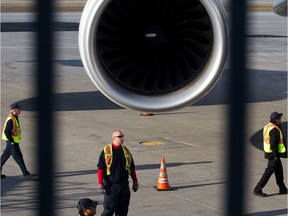 Airport workers walk around the turbine engine of the Air France Airbus A380 superjumbo flight 346 after it arrived from its first daily flight from Paris at the Montreal-Trudeau international airport in Montreal on Friday, April 22, 2011.