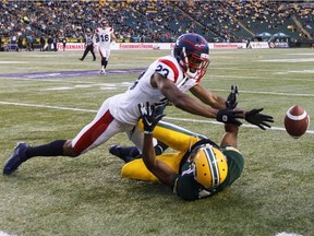Montreal Alouettes' Tommie Campbell, top, and Edmonton Eskimos' Kenny Stafford fight for a loose ball in Edmonton on June 14, 2019.