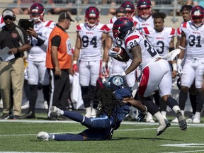 Montreal Alouettes' Jeremiah Johnson, right, fends Toronto Argonauts Abdul Kanneh in Moncton, N.B. on Sunday, Aug. 25, 2019.