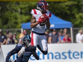 Montreal Alouettes' DeVier Posey makes a catch as Toronto Argonauts Jermaine Gabriel defends in Moncton, N.B., on Sunday, Aug. 25, 2019.