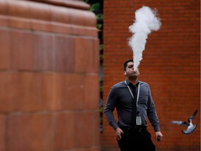 A man vapes outside an office block in Manchester, Britain, on Feb. 6, 2019.