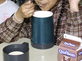 A girl at Bancroft School in 2002 eats a hot lunch of rice and vegetables out of a thermos.