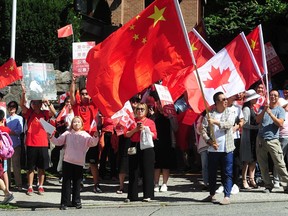Pro-Beijing supporters wave Chinese flags outside the Chinese Consulate on Granville Street in Vancouver.