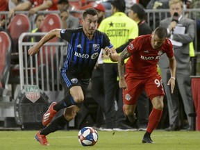 Montreal Impact defender Daniel Lovitz, left, moves the ball under pressure from Toronto FC defender Auro during first half in Toronto on Aug. 24, 2019.