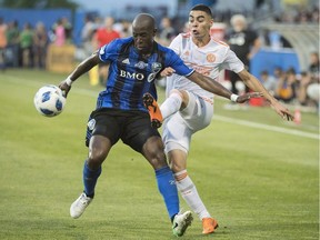 Montreal Impact's Rod Fanni, left, holds off a challenge by Atlanta United's Miguel Almiron during first half MLS soccer action in Montreal, Saturday, July 28, 2018. The Montreal Impact have signed French centre back Rod Fanni until the end of the 2019 season.
