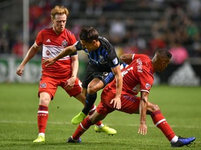 Montreal Impact midfielder Bojan Krkic (9) tries to dribble a ball between Chicago Fire midfielder Dax McCarty (6) and defender Johan Kappelhof (4) during the second half at SeatGeek Stadium.