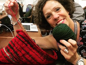 Sue Montgomery shows off scarf she is knitting during council meetings at Montreal city hall.