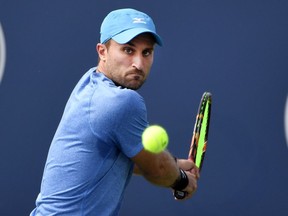 Steven Diez of Canada plays a shot against Bradley Klahn of the United States during the Rogers Cup tennis tournament at IGA Stadium in Montreal on Aug. 4, 2019.