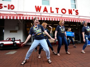 Walmart associates dance in front of Sam Walton's original 5 & 10 store, now a museum, during the annual shareholders meeting event on May 31, 2018 in Bentonville, Arkansas.