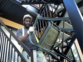 Lance Clarke, a partner in Barkley Transport, carries a chair to a waiting truck as he helps to move Andréa Lachapelle into an apartment in social housing.