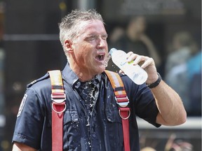 A firefighter pours water on his face while taking a break from fighting a fire on the corner of Bishop and de Maisonneuve in Montreal on Wednesday September 4, 2019.