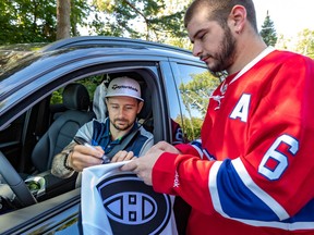 Canadiens fan Cedric Boucher gets a sweater autographed by Tomas Tatar on the way into the Laval-sur-le-Lac golf club.