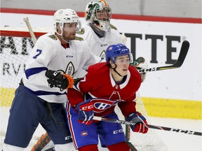 Quebec university all-star team's Guillaume Beaudoin cross-checks Montreal Canadiens rookie Rafael Harvey-Pinard in front of goalie Sebastien Auger during exhibition game at the Bell Sports Complex in Brossard on Tuesday, Sept. 10, 2019.