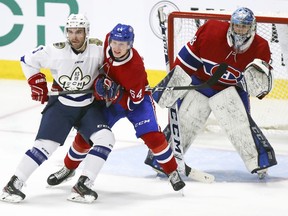Quebec university all-star Ryan Penny, left, battles for position in front of Canadiens rookie goalie Alexis Shank and defenceman Otto Leskinen during exhibition game at the Bell Sports Complex in Brossard on Tuesday.