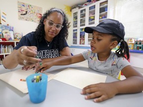 Chelsea Watts-Smith colours with her daughter, Jayda Watts-Simeon. They live at On Our Own, a community organization in Notre-Dame-de-Grâce working to help young parents — single mothers mostly — and their children to thrive.