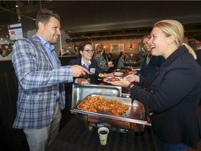 Yannick Pelletier, associate vice-president, commercial banking for the National Bank, serves potatoes to Marcia Ploplis, branch manager at the RBC Royal Bank branch in Beaconsfield, after he announced the bank would be contributing $500,000 to West Island Community Shares over five years, at the WICS campaign launch and breakfast in Pointe-Claire, Friday.