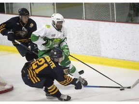 Cedrick Theodore from the West Island Shamrocks fights for the puck with Thomas Fredette (21) from the Granby Inouk in Pierrefonds on Sunday.