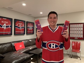 Canadiens fan Rob Hing in his Calgary home holding the season-ticket package he received this season after spending 10 years on the team's waiting list. Photo taken by Alayne Hing.