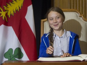 Swedish climate activist Greta Thunberg smiles after signing the City's Golden Book after the climate march on Friday, September 26, 2019 in Montreal. Thunberg and Mayor Valérie Plante met privately before there was ceremony where Thunberg received the keys to the city and signed the Golden Book of the city. (John Kenney / MONTREAL GAZETTE) ORG XMIT: 63213