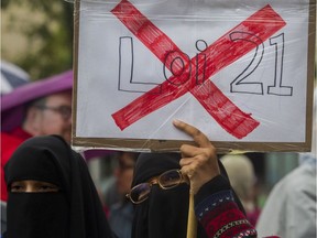 Zakia Khan holds a sign  at a rally teachers organized against Bill 21 in Montreal on Saturday.