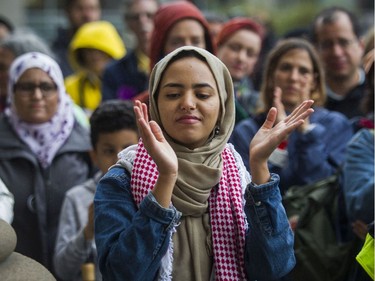 Tasnim Rekik applauds for a speaker at a rally teachers organized against Bill 21 in Montreal on Saturday, Sept. 28, 2019, outside the Parc métro station.