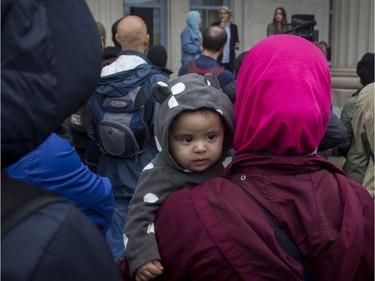 Maria Bouguerra is held by her mother, Samira Ighemate, at a rally against Bill 21 in Montreal on Saturday.