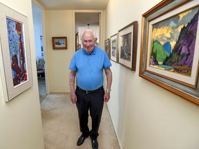 Andrew Harper walks down a hallway filled with original artwork in his Westmount home.