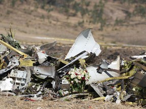 EJERE, ETHIOPIA - MARCH 13: A bouquet of flowers is placed in front of a pile of debris at the scene of the Ethiopian Airlines Flight 302 crash on March 13, 2019 in Ejere, Ethiopia. All 157 passengers and crew perished after the Ethiopian Airlines Boeing 737 Max 8 Flight came down six minutes after taking off from Bole Airport.