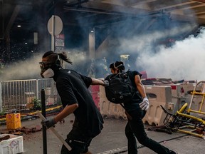 Pro-democracy protesters run after police fired tear gas at them during a clash after an anti-government rally in Tuen Mun district on September 21, 2019 in Hong Kong, China.