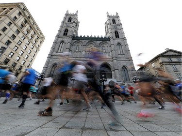 Competitors run past Notre Dame Basilica of Montreal during the Oasis International Marathon de Montreal - Day 2 on September 22, 2019 in Montreal.