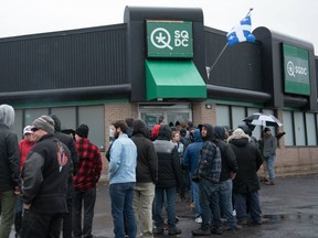 People line up outside of a cannabis store in Quebec City, Quebec on October 17, 2018.