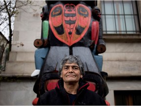 Charles Joseph stands with his 55-foot totem pole, Residential School Totem Pole (2014 -2017), outside the Museum of Fine Arts in Montreal on May 1, 2017.