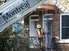 Montreal firefighters clean up after a fire that started on the top floor of a triplex in Verdun and spread to two attached triplexes on Sunday, Sept. 1, 2019. (