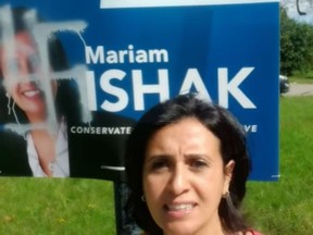 Mariam Ishak, the Conservative candidate in Pierrefonds-Dollard, stands in front of one of her campaign signs that had been defaced with a swastika, in a screengrab from a video she posted on Facebook Sept. 16, 2019. Credit: Facebook